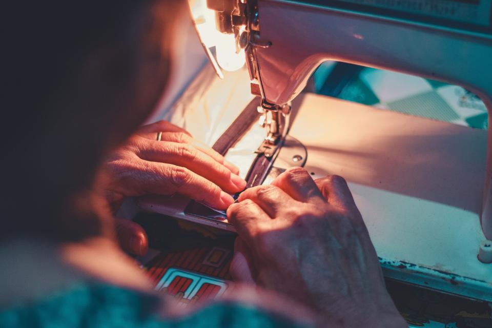 Hands working meticulously on a sewing machine project.