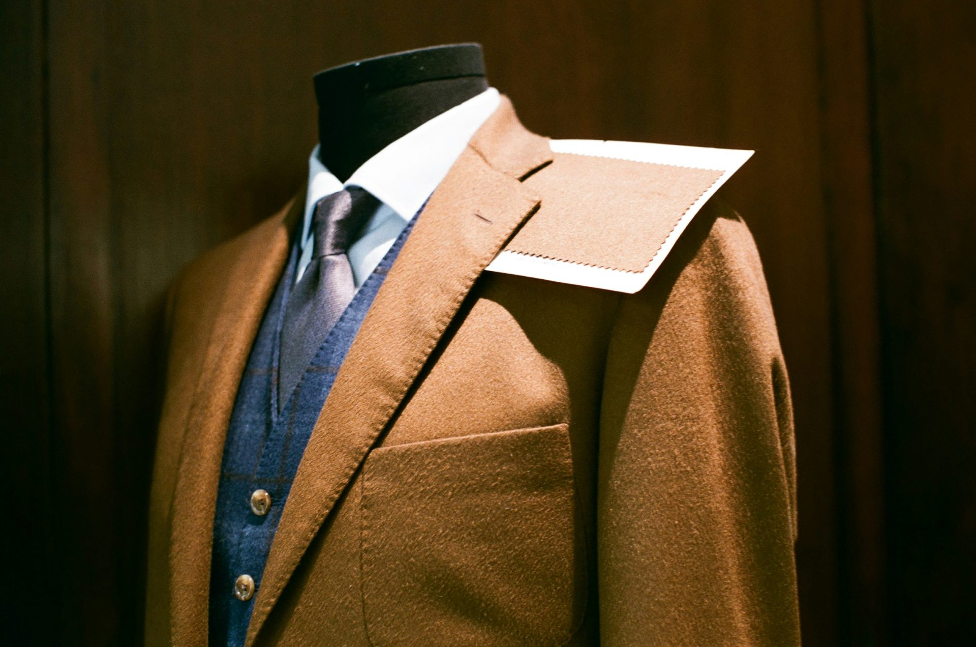 Tailored brown suit displayed on a mannequin with precision.